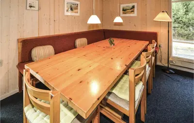 a wooden table in a room with chairs around it at Jydehuset in Fjerritslev