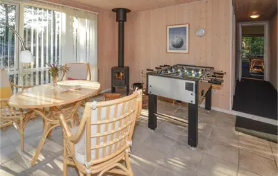 a kitchen with a stove and a table and a dining room at Jydehuset in Fjerritslev