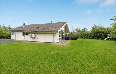 a white house with a large grass yard at Holiday Home Kronvildtvej Brovst I in Brovst