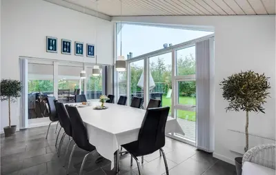 a dining room with a white table and chairs at Holiday Home Kronvildtvej Brovst I in Brovst