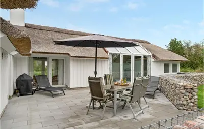 a patio with a table and chairs and an umbrella at Gorgeous Home In Fjerritslev With Wifi in Fjerritslev