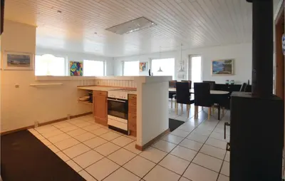 a kitchen and dining room with a table and chairs at Holiday Home Sandnæshagevej Frøstrup Iv in Frøstrup