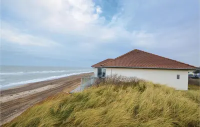a house on a hill next to a beach at Holiday Home Sandnæshagevej Frøstrup Iv in Frøstrup