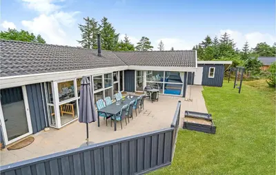 a house with a patio with a table and chairs at 4 Bedroom Stunning Home In Fjerritslev in Fjerritslev