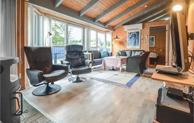 a living room with two chairs and a computer monitor at 4 Bedroom Stunning Home In Fjerritslev in Fjerritslev