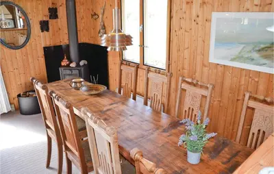 a dining room with a wooden table and chairs at Holiday Home Svenstibakkevej Frøstrup in Frøstrup