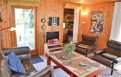 a living room with leather chairs and a table at Holiday Home Svenstibakkevej Frøstrup in Frøstrup