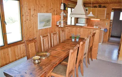 a long wooden table in a kitchen with chairs at Holiday Home Svenstibakkevej Frøstrup in Frøstrup