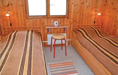 a room with two beds and a table and a stool at Holiday Home Svenstibakkevej Frøstrup in Frøstrup
