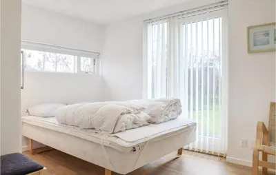 a bed in a room with a large window at Holiday Home Kronvildtvej Brovst in Brovst