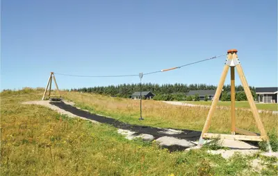 a swing set on a grassy hill with a road at Holiday Home Kronvildtvej Brovst in Brovst