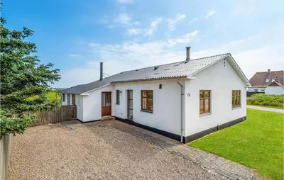 a white house with a fence and a yard at Holiday Home Strandvejen Harboøre X in Harboør