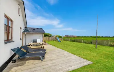 a deck with a bench and a picnic table at Holiday Home Strandvejen Harboøre X in Harboør