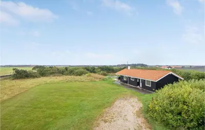 a small house in a field with a large yard at Holiday Home Hermodsvej Harboøre Xi in Harboør
