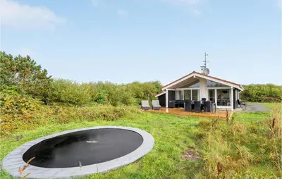 a house with a pond in the middle of a field at Holiday Home Hermodsvej Harboøre Xi in Harboør