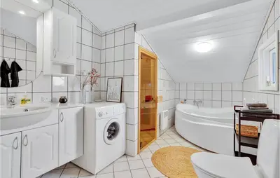 a white bathroom with a washing machine and a tub at Holiday Home Hermodsvej Harboøre Xi in Harboør