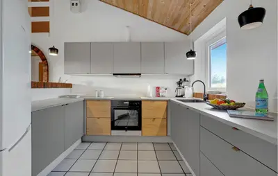 a kitchen with white cabinets and a sink at Holiday Home Viktoriavej Harboøre Ii in Harboør