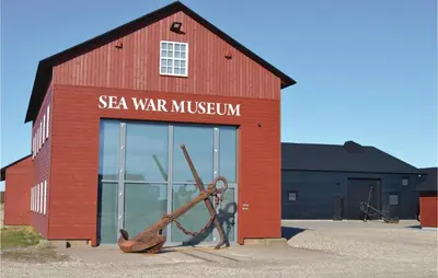 a red building with a sign on the side of it at Holiday Home Viktoriavej Harboøre Ii in Harboør