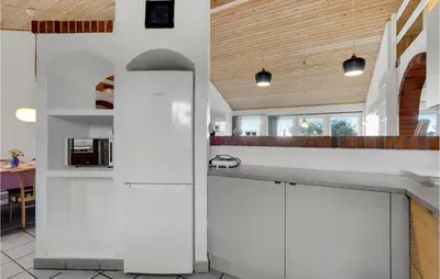 a kitchen with white counters and a wooden ceiling at Holiday Home Viktoriavej Harboøre Ii in Harboør