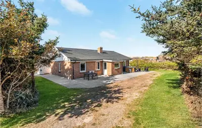a holiday cottage with a patio and a yard at Holiday Home Viktoriavej Harboøre Ii in Harboør