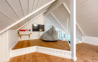 a living room with a couch in the corner of a room at Holiday Home Gloryvej Harboøre Iv in Harboør