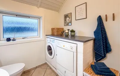 a washing machine in a bathroom with a window at Holiday Home Gloryvej Harboøre Iv in Harboør