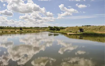 a river with a reflection of clouds in the water at Holiday Home Gloryvej Harboøre Iv in Harboør