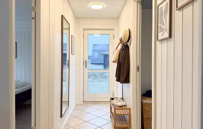a hallway of a home with a door and a coat at Holiday Home Gloryvej Harboøre Iv in Harboør