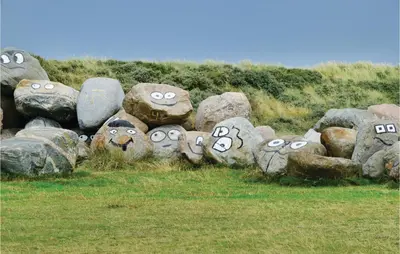 a bunch of rocks with faces painted on them at Holiday Home Vejlby Klit Harboøre V in Harboør