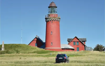 a car parked in front of a red lighthouse at Holiday Home Vejlby Klit Harboøre V in Harboør