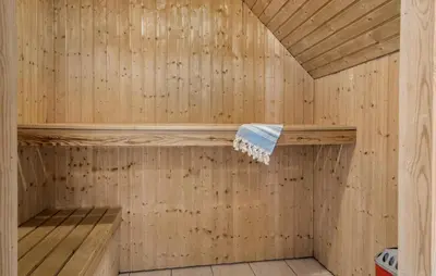 a wooden sauna with a towel on a shelf at Gorgeous Home In Harboøre With Sauna in Harboør