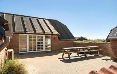 a picnic bench in front of a brick building at Gorgeous Home In Harboøre With Sauna in Harboør