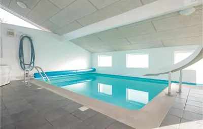 a swimming pool in a building with a blue pool at Amazing Home In Saltum With Wifi in Saltum