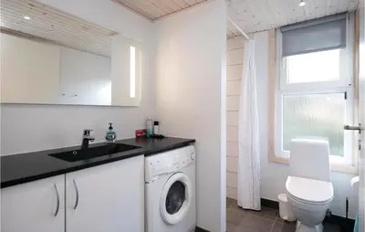 a bathroom with a washing machine and a sink at Amazing Home In Saltum With Wifi in Saltum