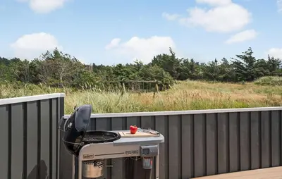 a barbecue grill on the back of a fence at Holiday Home Monasvej Løkken Iv in Løkken