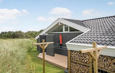 a tiny house with a deck and a window at Holiday Home Monasvej Løkken Iv in Løkken