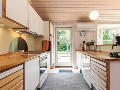 a kitchen with white cabinets and a large window at 6 person holiday home in Løgstør in Løgsted
