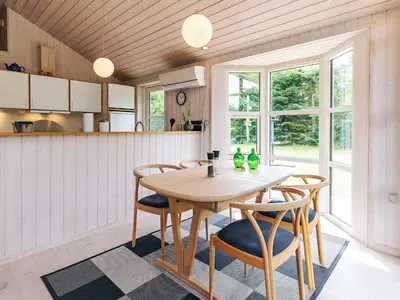 a dining room with a wooden table and chairs at 6 person holiday home in Løgstør in Løgsted