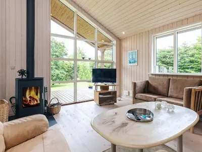 a living room with a table and a fireplace at 6 person holiday home in Løgstør in Løgsted
