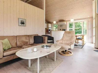 a living room with a couch and a table at 6 person holiday home in Løgstør in Løgsted