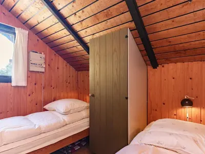 a bedroom with two beds in a room with wooden walls at 8 person holiday home in Løgstør-By Traum in Løgstør