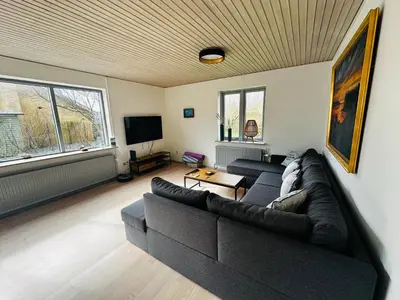 a living room with a couch and a tv at Beautiful villa close to beach and nature in Hanstholm