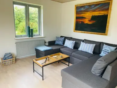 a living room with a couch and a table at Beautiful villa close to beach and nature in Hanstholm