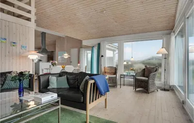 a living room with a couch and a table at Holiday Home Monasvej Xii in Løkken