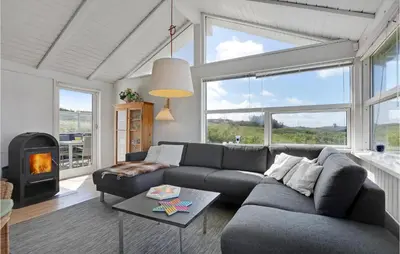a living room with a couch and a fireplace at Pynten in Løkken