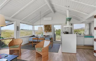 a kitchen and dining room with a table and chairs at Pynten in Løkken