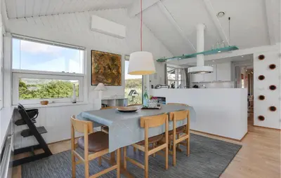 a kitchen and dining room with a table and chairs at Pynten in Løkken