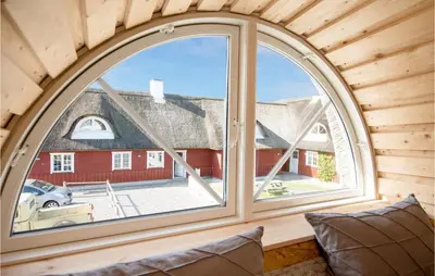 an arched window in a room with a view of a house at Holiday Home Rødhus Klitvej in Pandrup