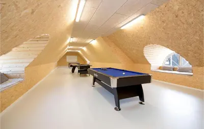 an attic room with a pool table and stairs at Holiday Home Rødhus Klitvej in Pandrup