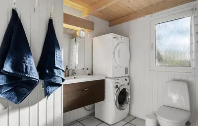 a small bathroom with a washing machine and a washer at 4 Bedroom Awesome Home In Saltum in Saltum